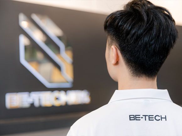 a picture of a man showing be tech logo on his back shirt